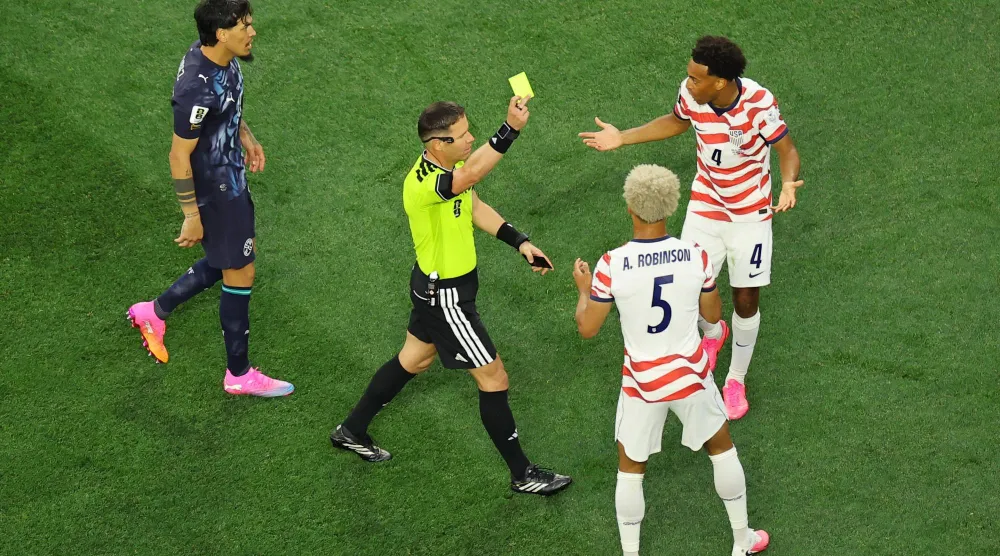 تيم ريم مدافع المنتخب الأميركي يتلقى الإنذار الذي سحب فيما بعد (رويترز)