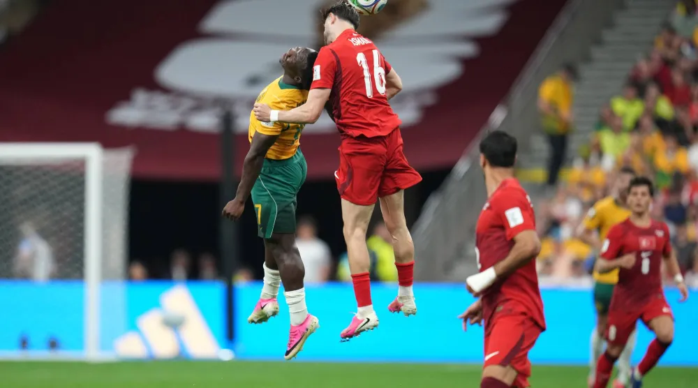 Australia's Nestory Irankunda (17) and Türkiye's Ismail Yuksek (16) jump to head the ball during the World Cup Group D soccer match between Australia and Türkiye in Vancouver, British Columbia, Saturday, June 13, 2026. (AP Photo/Abbie Parr)