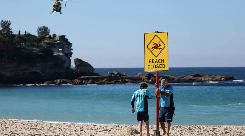 FILE PHOTO: Lifeguards erect a sign that says "Beach Closed" following a shark attack at Coogee Beach in Sydney, Australia, June 13, 2026. REUTERS/Hollie Adams/File Photo
