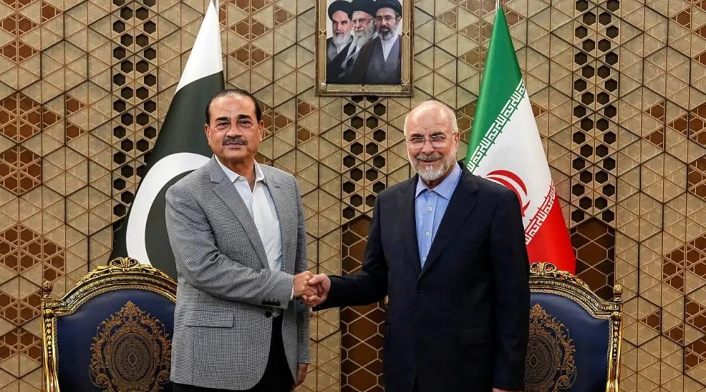 رئيس البرلمان الإيراني محمد قاليباف مصافحاً قائد الجيش الباكستاني المشير عاصم منير في طهران 23 مايو (رويترز)