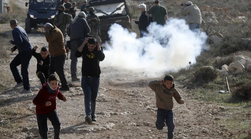جنود إسرائيليون ومستوطنون يمنعون فلسطينيين من الوصول إلى حقولهم الزراعية في قرية ترقوميا بالضفة الغربية (د.ب.أ)