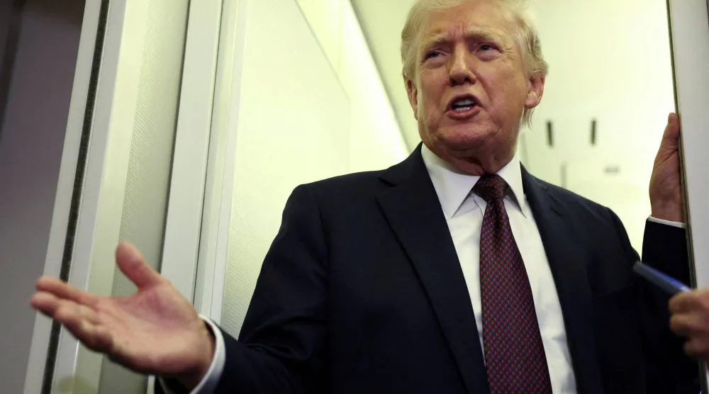 US President Donald Trump speaks to reporters aboard Air Force One on a flight back to Washington March 15, 2026. REUTERS/Kevin Lamarque/File Photo