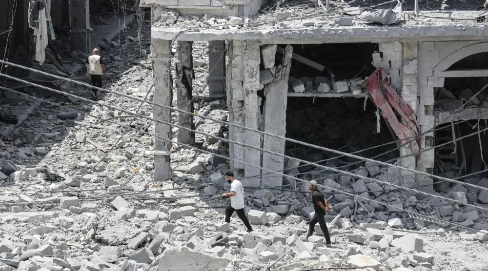 أشخاص يشقّون طريقهم عبر أنقاض مبنى مدمر بينما يعود سكان نازحون إلى النبطية في جنوب لبنان... 15 يونيو 2026 (أ.ف.ب)