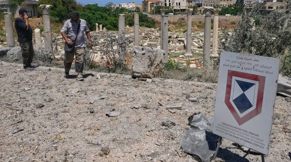 سكان يتفقدون موقع الآثار الرومانية في مدينة صور بجنوب لبنان بعد استهداف محيطها بغارات إسرائيلية (أ.ب)