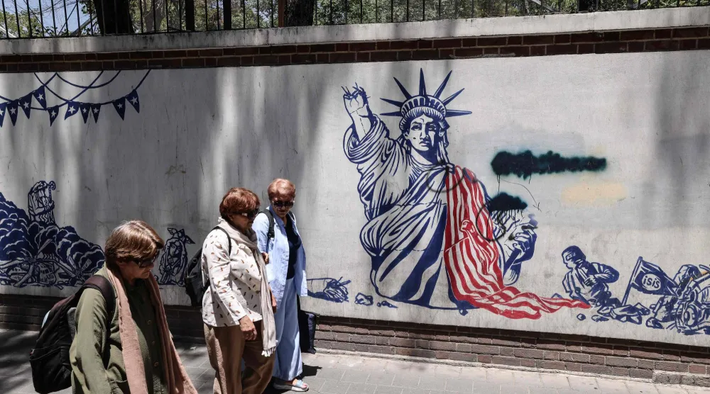 إيرانيات يمررن أمام جدارية مناهضة للولايات المتحدة خارج مبنى السفارة الأميركية السابقة في طهران(أ.ف.ب)