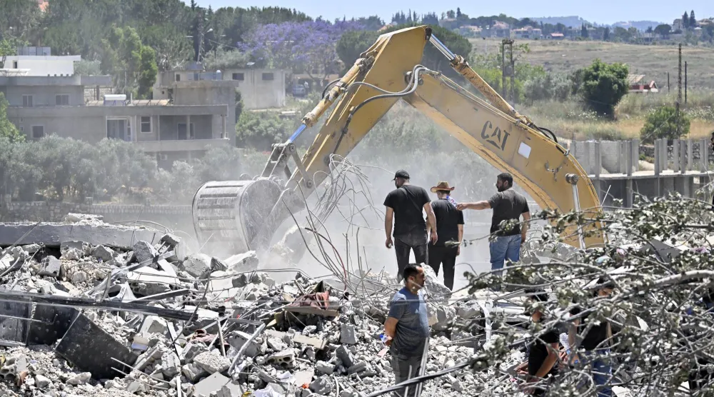 سكان عادوا إلى قريتهم يستخدمون حفارة للبحث عن مفقودين تحت أنقاض مبنى مدمر في قرية تولين جنوب لبنان 16 يونيو 2026 (إ.ب.أ)