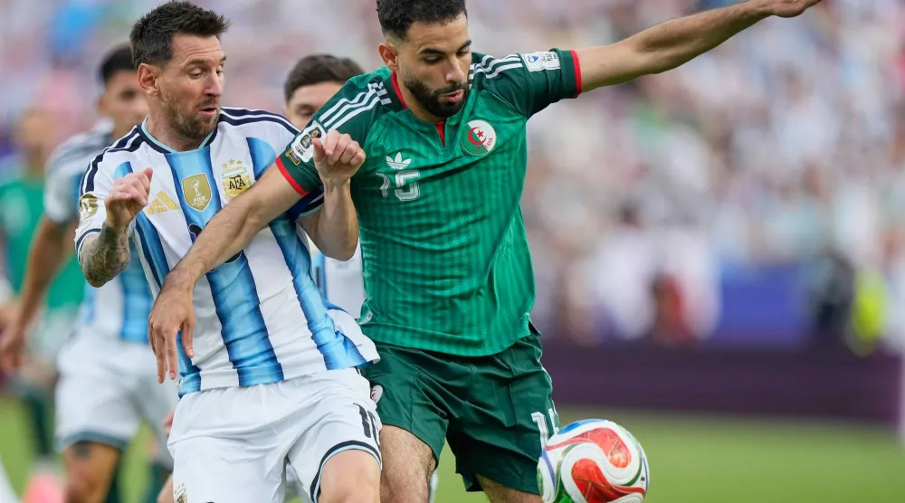 ميسي في صراع على الكرة مع آيت نوري لاعب الجزائر (أ.ب)