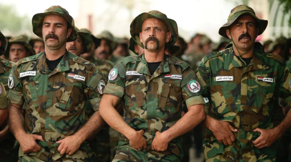 عناصر من «الحشد الشعبي» في العراق خلال استعراض عسكري (موقع الهيئة)
