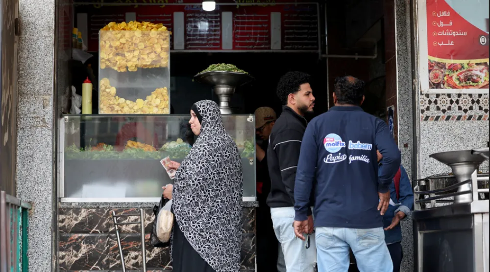 مصريون يشترون طعام الإفطار من أحد المطاعم في القاهرة (رويترز)