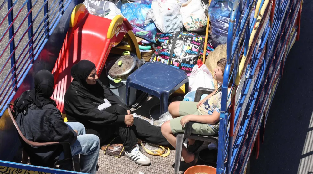 شاحنة تقل هاربين من الغارات الإسرائيلية على قرى الجنوب  اللبناني عند مدخل صيدا في طريقهم إلى بيروت أمس (أ.ف.ب) 