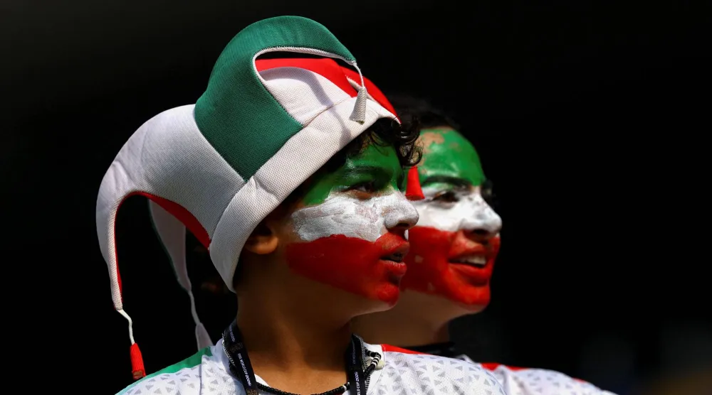 مشجعان إيرانيان يساندان منتخب بلادهما أمام نيوزيلندا (رويترز)