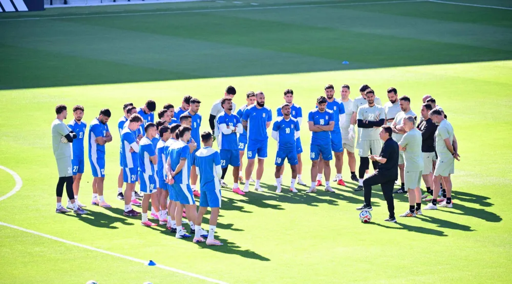 مدرب إيران خلال حديثه مع اللاعبين قبل انطلاق الحصة التدريبية (أ.ف.ب) 