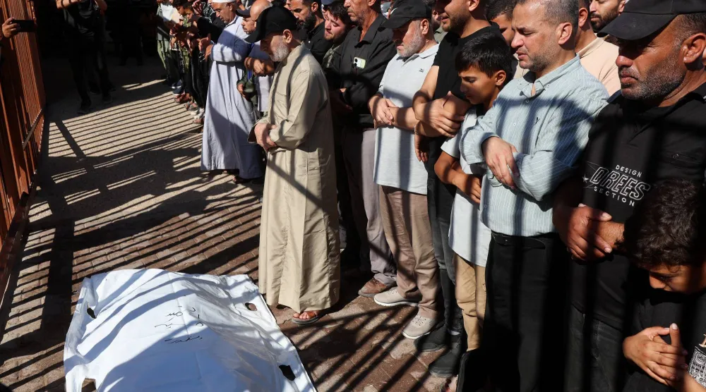مشيعون يؤدون صلاة الجنازة على فلسطينيين قتلوا في ضربات إسرائيلية في خان يونس (رويترز)