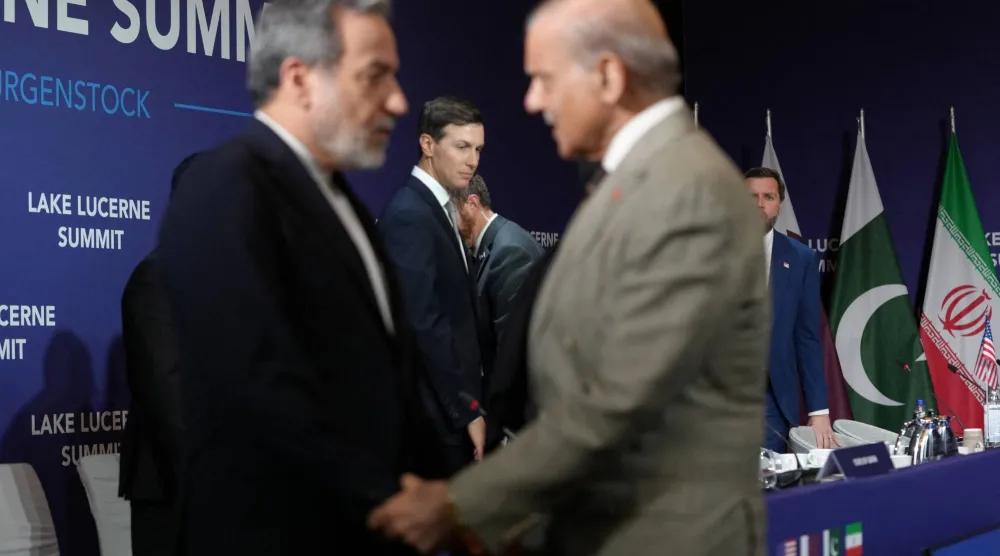 وزير الخارجية الإيراني عباس عراقجي أثناء مصافحته رئيس الوزراء الباكستاني شهباز شريف قبيل انطلاق الاجتماع الرباعي في منتجع بورغنشتوك السويسري (رويترز)