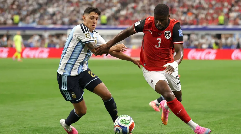 لاعب النمسا كيفن دانسو يسيطر على الكرة تحت ضغط لاعب الأرجنتين ناويل مولينا (أ.ف.ب)