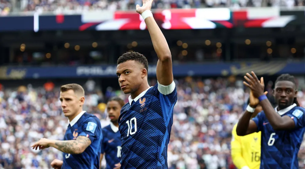 كيليان مبابي قائد منتخب فرنسا يحيي الجماهير أثناء دخوله إلى أرض الملعب (أ.ف.ب)
