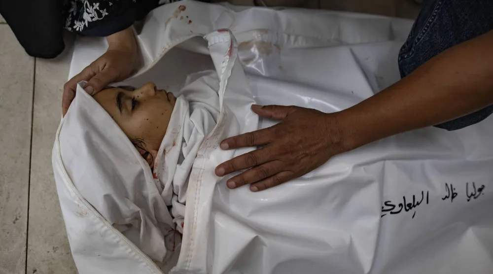 جثمان الطفلة جولي البلاوي وعمرها 8 أعوام بمستشفى الناصر في خان يونس بعد مقتلها جراء القصف الإسرائيلي على قطاع غزة (إ.ب.أ)