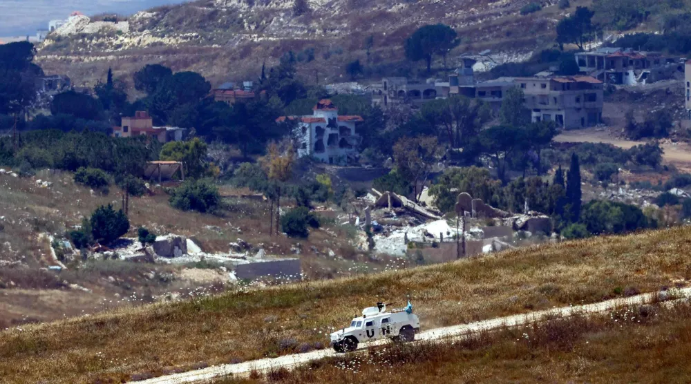 This picture taken from a position in northern Israel, near the border with Lebanon shows a United Nations Interim Force in Lebanon (UNIFIL) armored vehicle driving past destroyed buildings in southern Lebanon on June 22, 2026. (AFP)