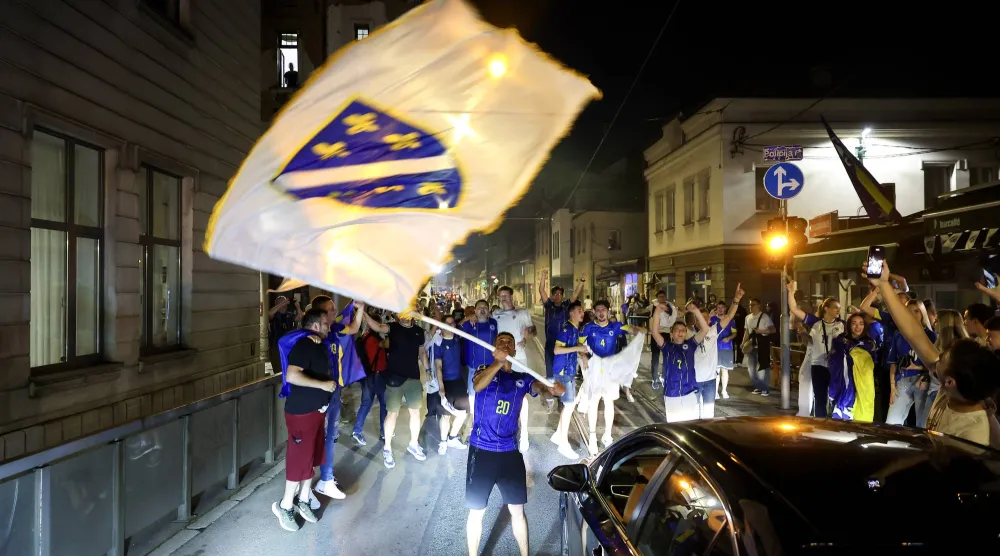 مواطنون بوسنيون يحتفلون بتأهل منتخب بلادهم إلى دور الـ32 (أ.ب)
