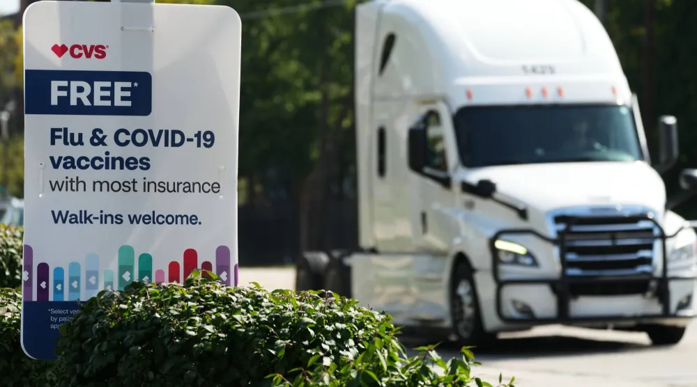 FILE - A sign for flu & COVID-19 vaccines is displayed outside a CVS store in Buffalo Grove, Ill., Sept. 23, 2025. (AP Photo/Nam Y. Huh, file)