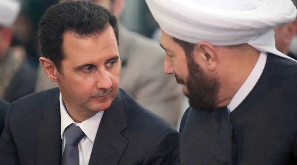 مفتي سوريا السابق مع الرئيس المخلوع بشار الأسد (أرشيفية)