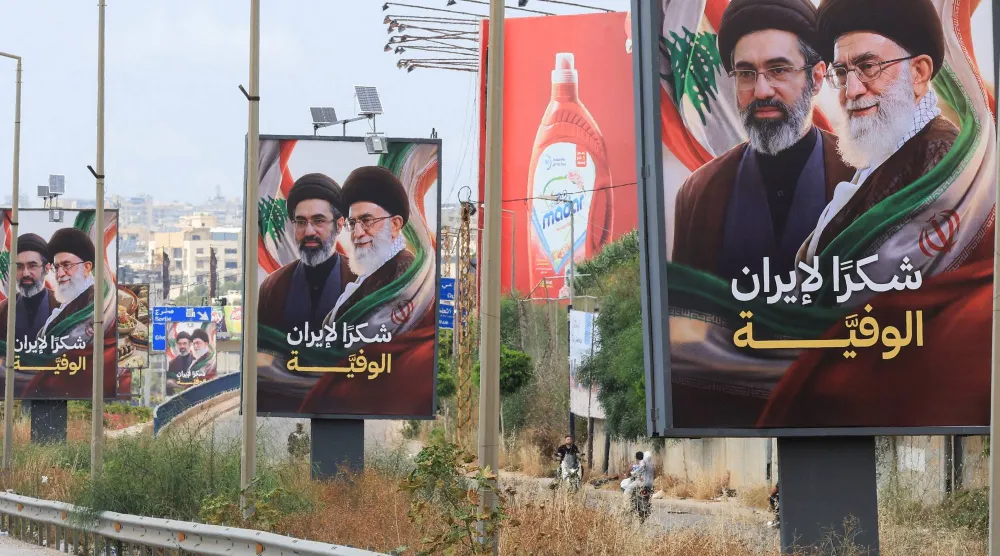 لافتات تحمل صور المرشد الإيراني مجتبى خامنئي ووالده علي خامنئي مرفقة بعبارة شكراً لإيران رفعت على طريق المطار باتجاه جنوب لبنان (رويترز)
