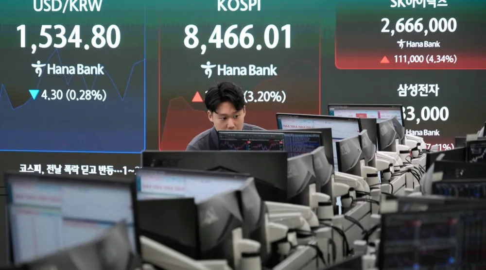 متداول يتابع شاشة تعرض مؤشر كوسبي وسعر صرف الدولار مقابل الوون داخل قاعة تداول بنك هانا في سيول (أ ب)