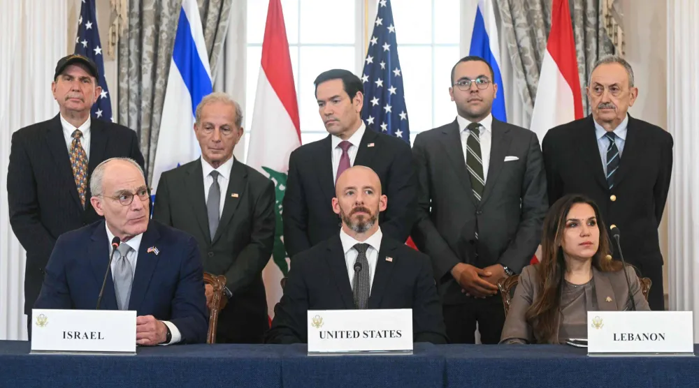 المسؤول في وزارة الخارجية الأميركية دانيال هولر بين سفيرة لبنان ندى حمادة معوض وسفير إسرائيل يحيئيل ليتر بعد توقيع الاتفاق. وبدا وزير الخارجية الأميركي ماركو روبيو في وسط الصف الخلفي. (أ.ف.ب)
