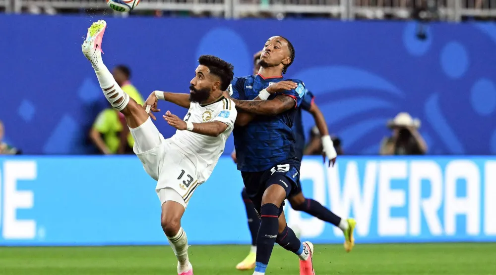 نواف بوشل لاعب المنتخب السعودي في صراع على الكرة (أ.ف.ب)