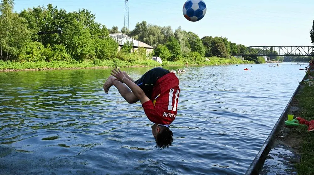 A boy jumps into the Dortmund-Ems Canal in Dortmund, western Germany on June 26, 2026 during a heatwave in Europe. (AFP)