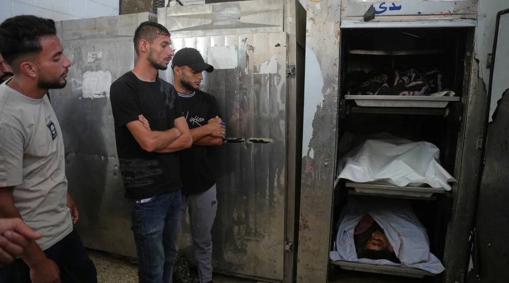 لقي المشيعون النظرة الأخيرة على جثامين رجال فلسطينيين قُتلوا في غارة جوية إسرائيلية على مخيم المغازي للاجئين أمس (الجمعة) وذلك خلال جنازتهم في دير البلح - قطاع غزة (أ.ب)