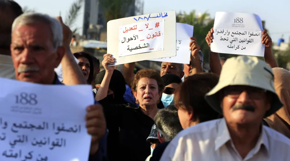 عراقية تحمل لافتة «لا لتعديل قانون الأحوال الشخصية» خلال احتجاج وسط بغداد في أغسطس 2024 (إ.ب.أ)