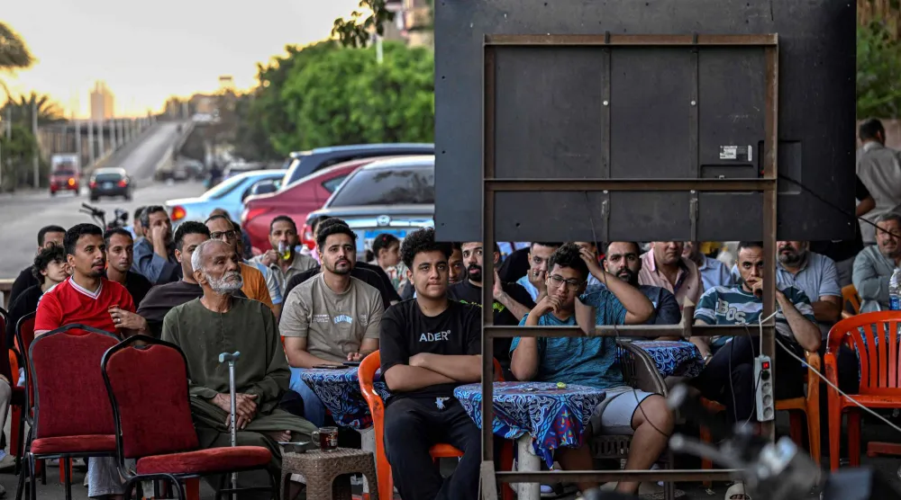 مصريون يتابعون مباراة «الفراعنة» أمام إيران بالقاهرة (أ.ف.ب)