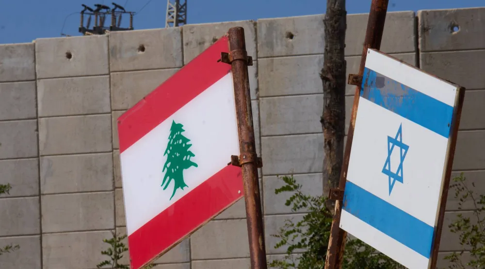 علمان لبناني وإسرائيلي في موقع تذكاري قرب الحدود بين إسرائيل ولبنان خارج مستوطنة المطلة في إسرائيل (أ.ب)