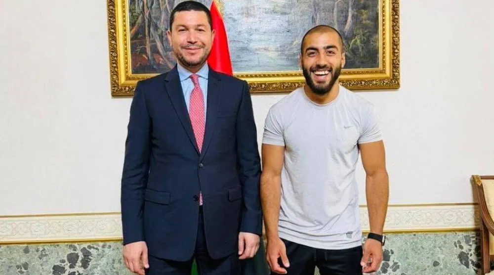 السفير الليبي لدى إيطاليا مع أحد المواطنين المفرج عنهم بمقر السفارة في روما الجمعة (صفحة السفارة)