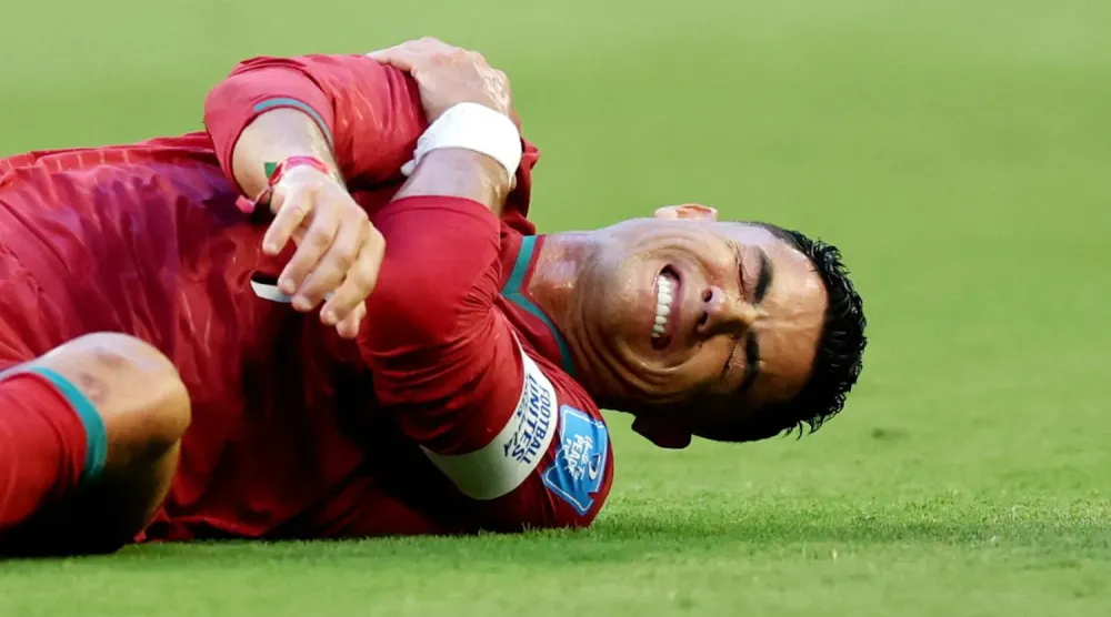 Portekiz Milli Takımı'nın kaptanı Cristiano Ronaldo, Kolombiyalı bir oyuncuyla girdiği ikili mücadele sonrası acı içinde yerde kaldı. (Reuters)