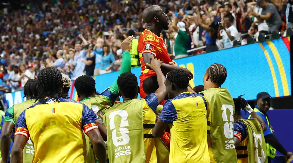 لاعب الكونغو يوان ويسا يحتفل بتسجيل الهدف الثالث مع زملائه (رويترز)