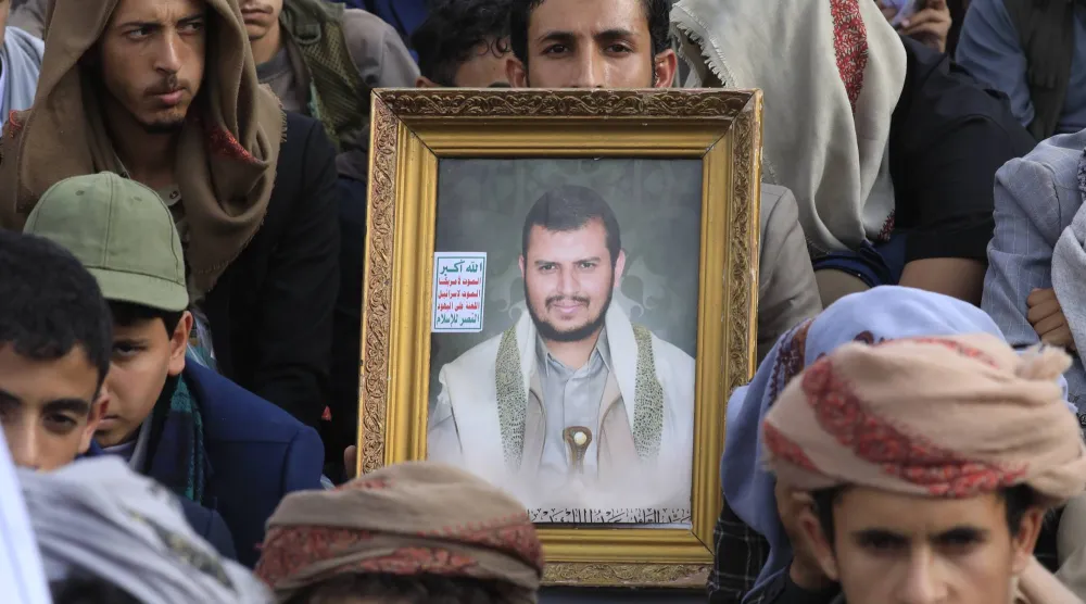 عناصر حوثيون يرفعون صورة زعيمهم خلال حشد في صنعاء (إ.ب.أ)