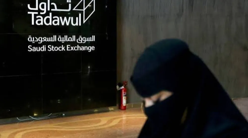 امرأة سعودية تمشي في السوق المالية السعودية (رويترز)