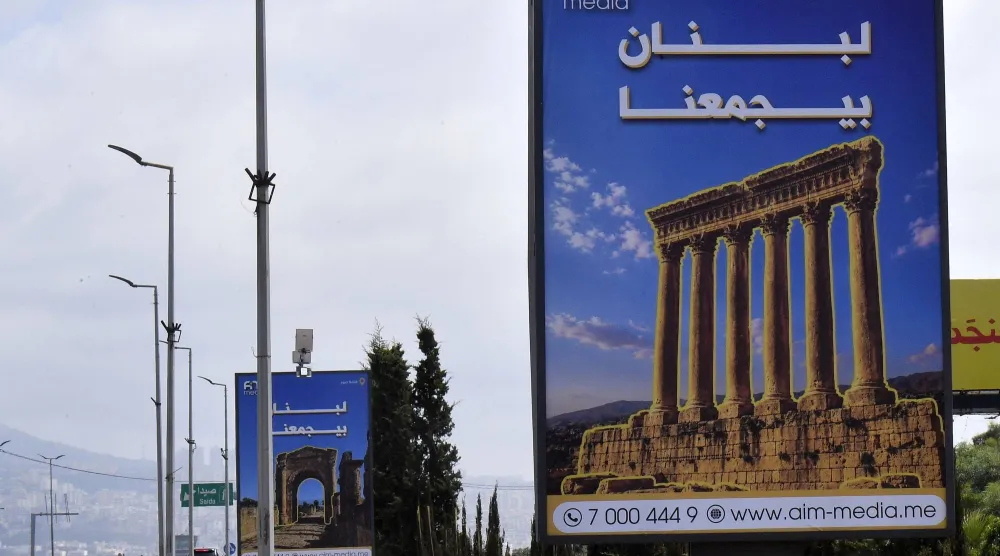 لوحات إعلانية تحمل شعار «لبنان يجمعنا» مثبتة على طريق مطار رفيق الحريري الدولي في بيروت (إ.ب.أ)