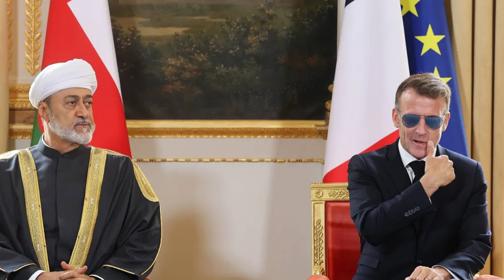 سلطان عمان والرئيس الفرنسي يتابعان توقيع الوزراء والمسؤلين من الجانبين على الاتفاقيات (أ.ب)