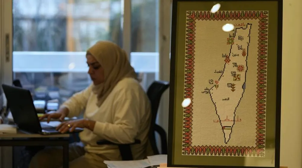 A hand-embroidered map of historic Palestine with names of cities and the words “Palestine” and “Returning” in Arabic is displayed at the Inaash Association embroidery workshop in Beirut, Tuesday, May 19, 2026. (AP) 