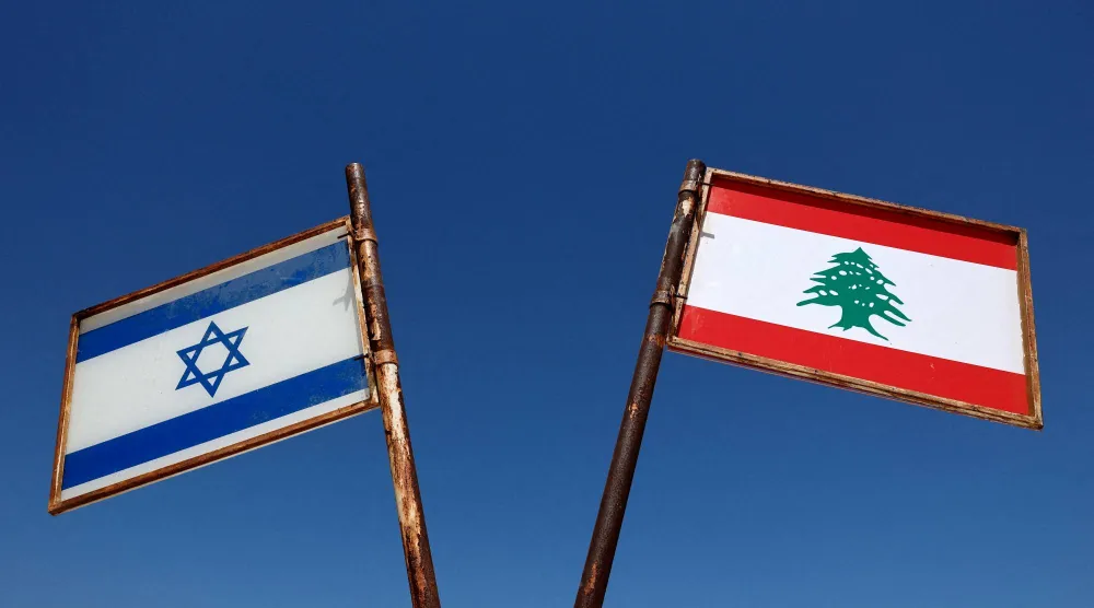 علما لبنان وإسرائيل مرفوعان في بلدة المطلة في شمال إسرائيل المحاذية للحدود اللبنانية (رويترز)