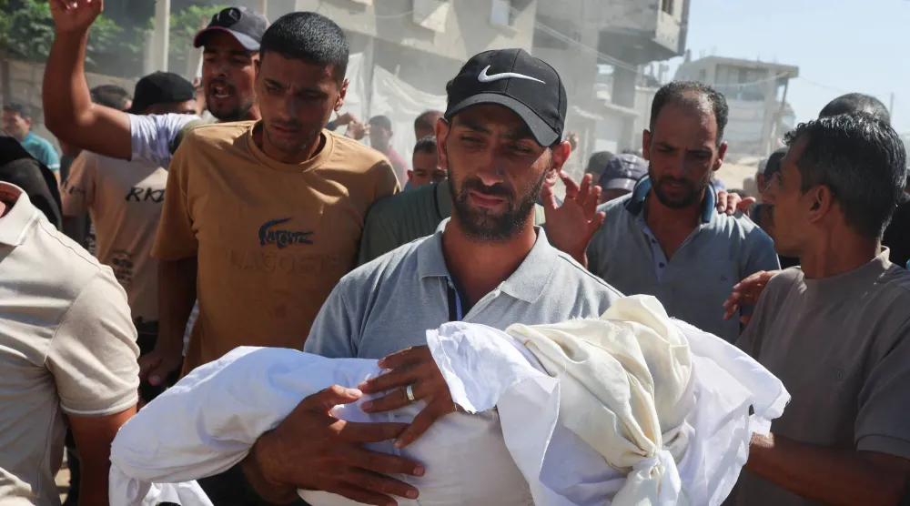 فلسطينيون يشيِّعون رضيعة قُتلت مع أمها بغارة إسرائيلية في خان يونس جنوب غزة (رويترز)