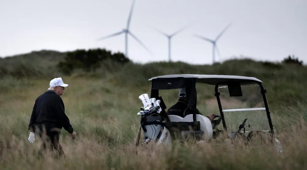 İskoçya'nın Aberdeenshire kentindeki golf sahasında görülen Donald Trump'ın rüzgar santrallerini sert bir şekilde eleştirdiği biliniyor (AFP)