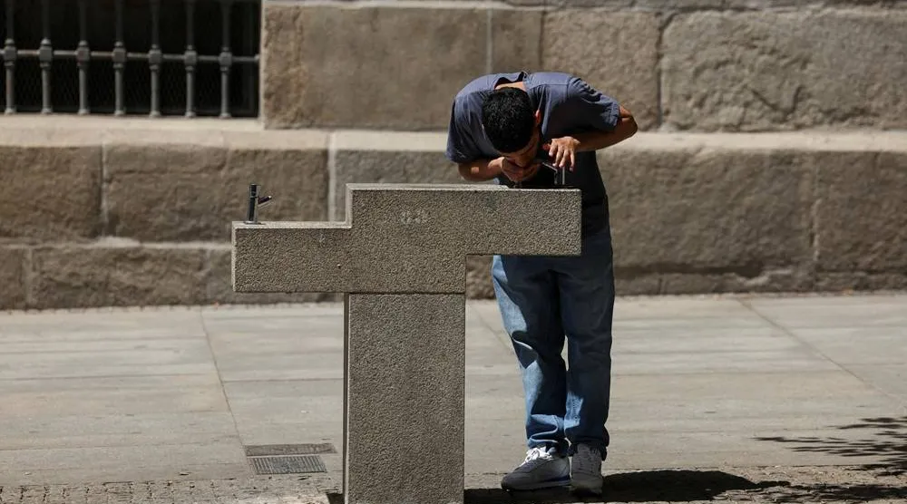 A person drinks from a fountain rest during a spring heatwave in Madrid, Spain, May 27, 2026. (Reuters)