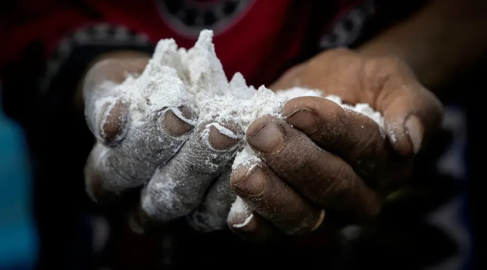 Yemen’deki bir mülteci kampında bulunan bir kadın, ailesi için yemek hazırlamak üzere elinde bir avuç un tutuyor. (AP)