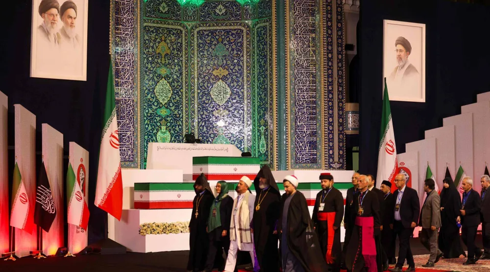 مسؤولون محليون وأجانب يسيرون أمام نعوش المرشد الإيراني علي خامنئي وأفراد عائلته في طهران (أ.ف.ب)