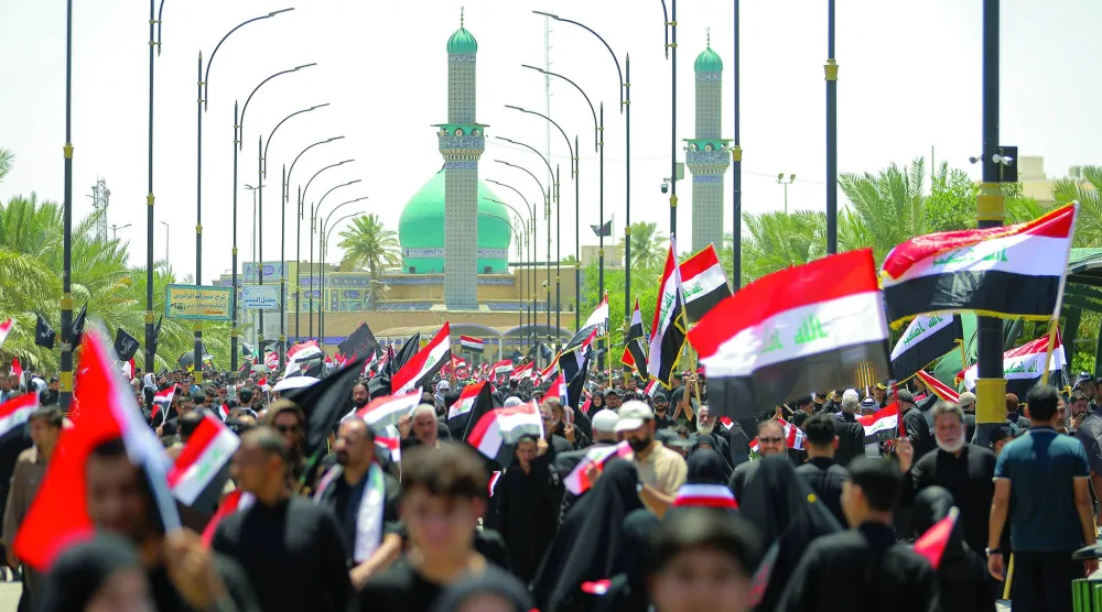 أنصار رجل الدين مقتدى الصدر يلوّحون بالعلم العراقي خلال مظاهرة دعماً لإجراءات الحكومة العراقية لمكافحة الفساد، في النجف، أمس الجمعة. (أ.ب)