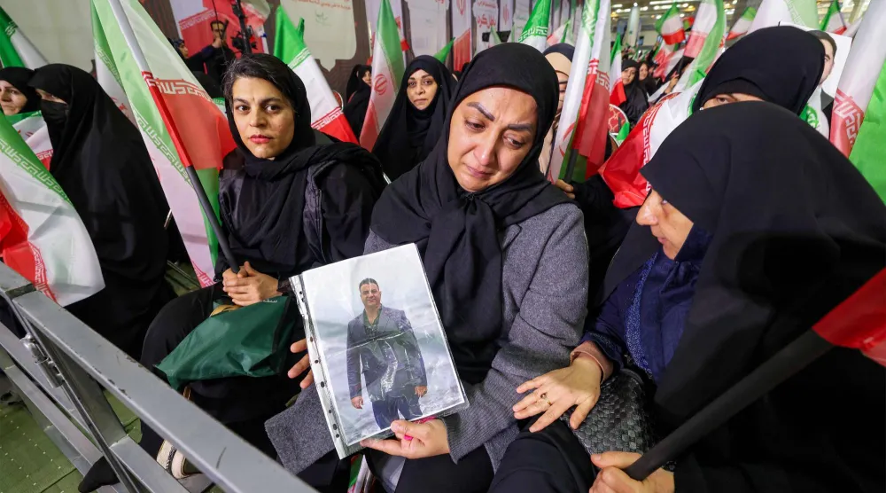 امرأة في طهران تحمل صورة لشخص قُتل في احتجاجات سابقة مناهضة للحكومة في إيران (أ.ف.ب)